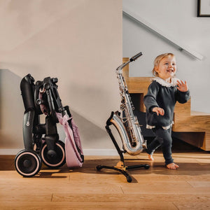Triciclo Kinderkraft JAZZ 3 rosa plegado de forma compacta para facilitar el almacenamiento y el transporte en casa.