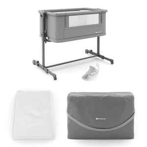 Cuna 3 en 1 NESTE GROW 2 de Kinderkraft gris: cuna colecho para bebé, cuna y cuna para niños mayores. Ajustable en 5 niveles de altura y 2 de inclinación, plegable y resistente, con 2 ruedas con bloqueo. De RN a 2 años. Vista lateral con bolso de transporte, correas y colchón.