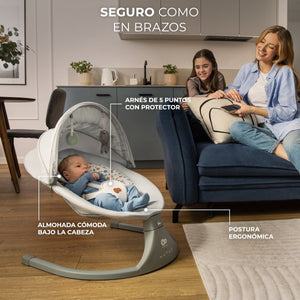 Bebé en mecedora eléctrica Kinderkraft LUMI 2 gris con arnés de 5 puntos y almohada ergonómica, mamá usando mando a distancia en salón moderno