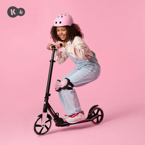 Niña con casco montando scooter Kinderkraft FREELY color rosa con ruedas PU grandes, scooter para niños desde 5 años con manillar ajustable en altura