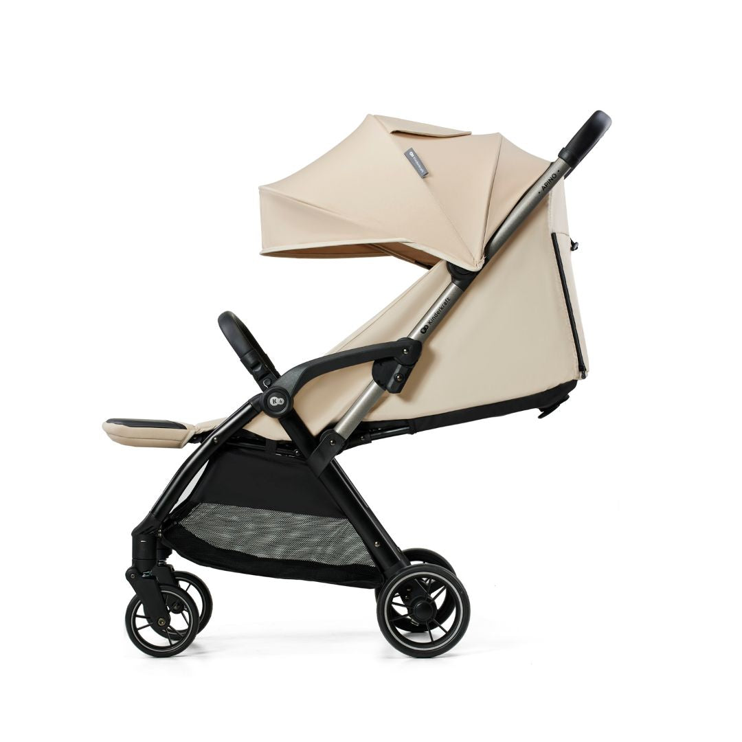 Coche Travel System Kinderkraft APINO beige con respaldo reclinado, capota grande y ruedas antipinchazos con detalle dorado, vista lateral