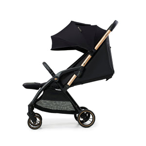 Coche de paseo Kinderkraft APINO negro con respaldo reclinado, capota grande y ruedas antipinchazos con detalle dorado, vista lateral
