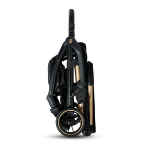 Coche de paseo Kinderkraft APINO negro plegado de pie con sistema AUTO FOLDING, estructura compacta con detalles dorados, vista lateral
