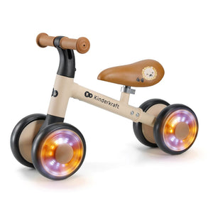 Triciclo correpasillos Kinderkraft CUTIE FLASH beige con ruedas con rodamiento ABEC-7 y luces LED RGB, sillín acolchado ajustable. Andador con estructura de acero estable. Vista lateral.