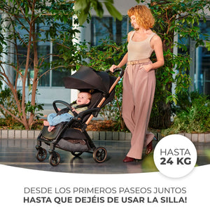 Mamá paseando a su bebé en coche Kinderkraft APINO negro en ciudad, apto desde recién nacido hasta 24 kg con respaldo reclinable