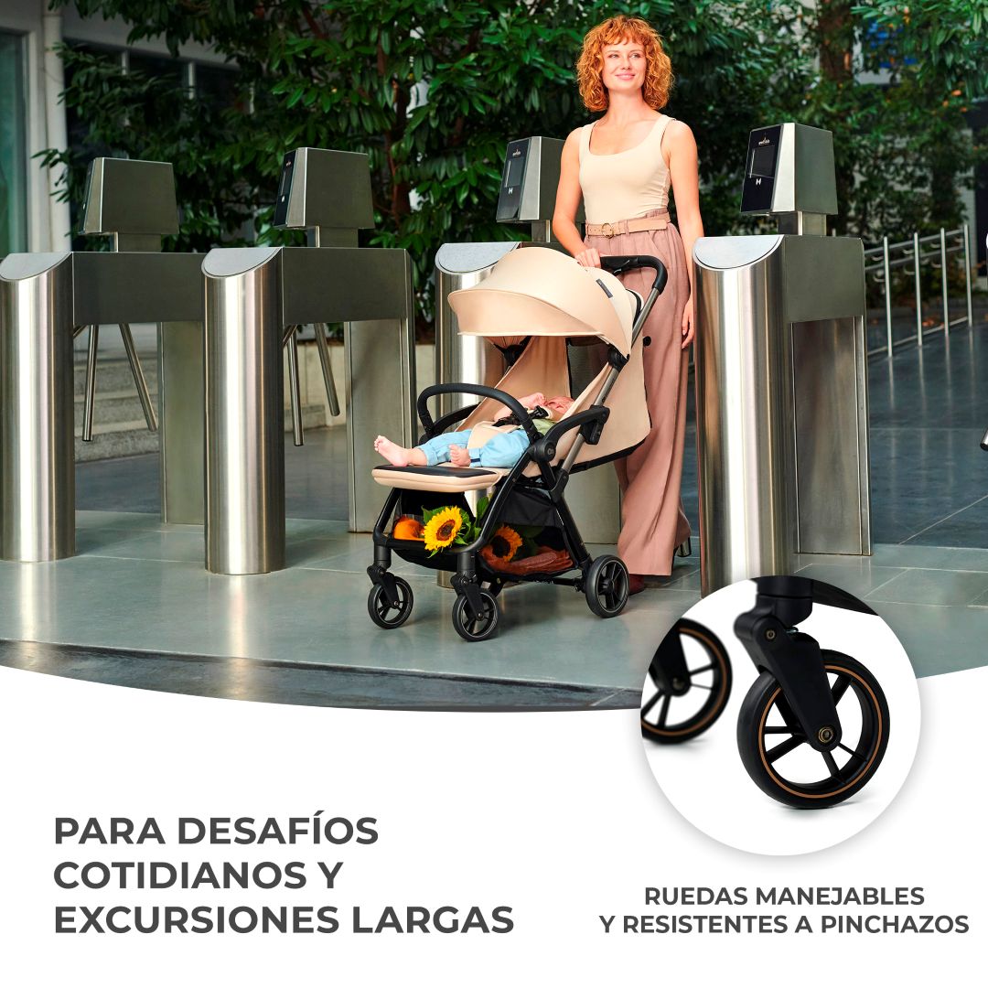Mamá paseando con coche Kinderkraft APINO beige en aeropuerto, ruedas delanteras 360° antipinchazos con suspensión para todo terreno