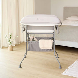 Mudador Kinderkraft BUBBLY sobre estructura alta gris en habitación nórdica, cesta inferior con accesorios incluida, 5 configuraciones posibles
