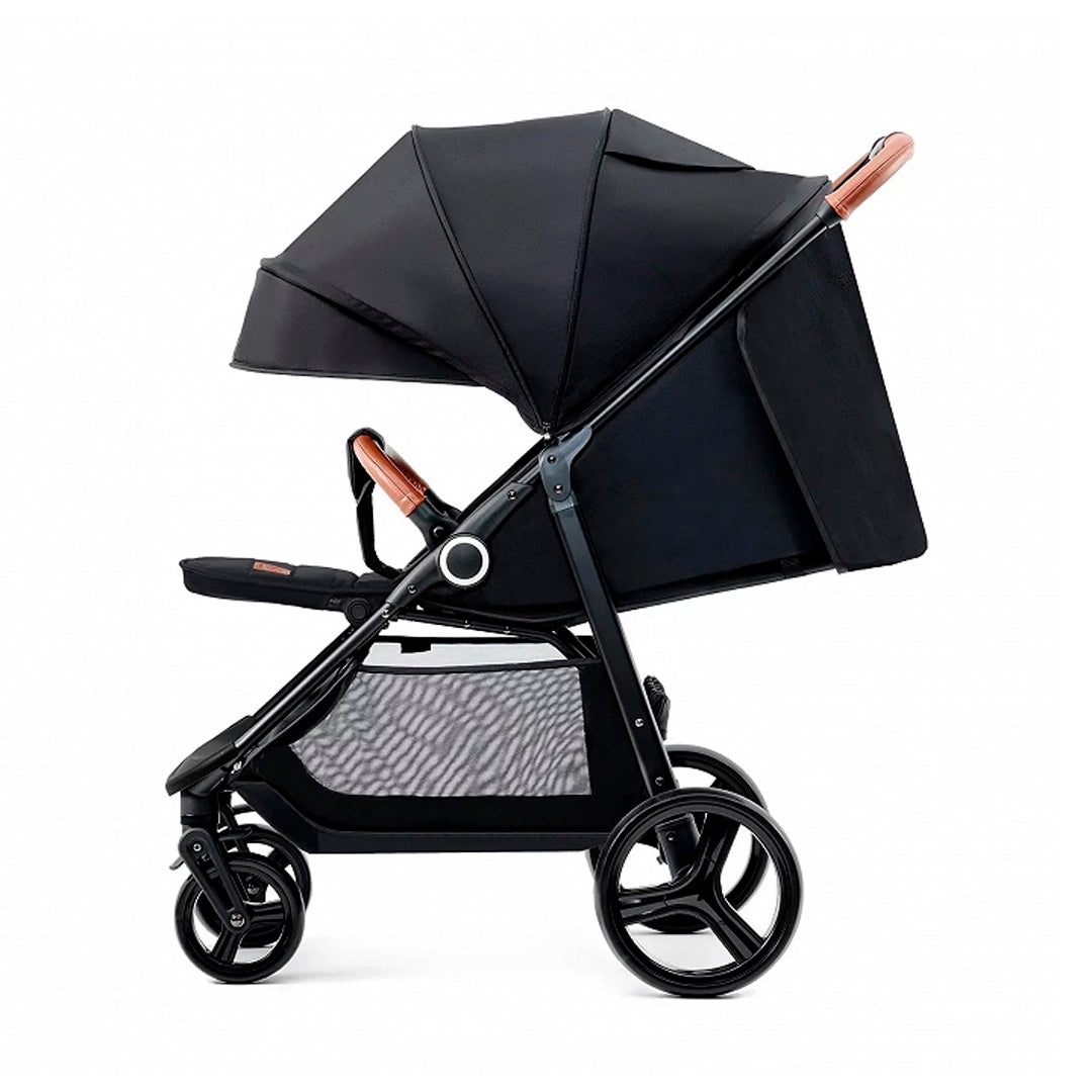 Coche de paseo Kinderkraft GRANDE PLUS negro en posición tumbada, capota amplia extensible, ruedas antipinchazos con suspensión y manillar con detalles en cuero caramelo