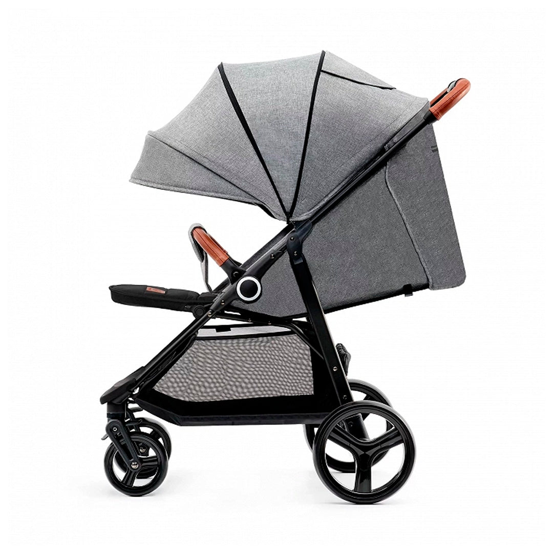 Coche de paseo Kinderkraft GRANDE PLUS gris en posición tumbada, capota amplia extensible, ruedas antipinchazos con suspensión y manillar con detalles en cuero caramelo