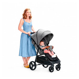 Mamá paseando con bebé en coche Kinderkraft GRANDE PLUS gris, capota extensible con ventanilla, ruedas antipinchazos ideales para ciudad, hasta 22 kg o 4 años