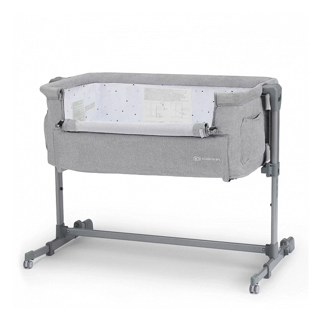 Cuna colecho Kinderkraft NESTE UP gris claro, vista frontal con estructura gris, ventana de malla plegada y ruedas, altura regulable en 5 niveles